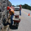  color photograph of work crew shoveling cinders from road gutter