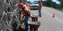 color photograph of Public Lands Crew digging weeds and cinders from volcano road gutter