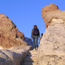 A hiker meanders across the top of El Morro