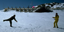a photo of folks throwing snowballs in front of the snow-covered Alpine Visitor Center