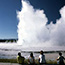 A family watches a geyser erupt.