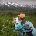 Young girl using a field guide from the Grand Teton Association