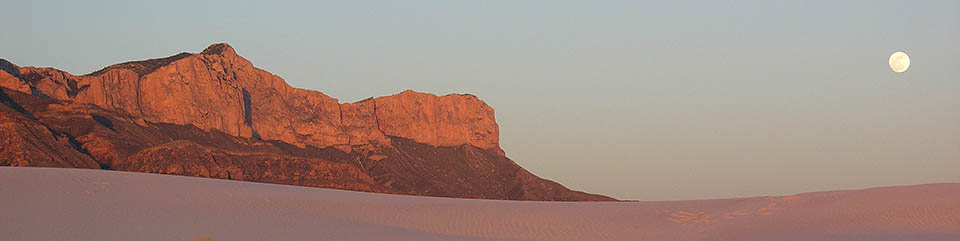 The Western Escarpment of the Guadalupes rises above the white gypsum sands of the desert floor.