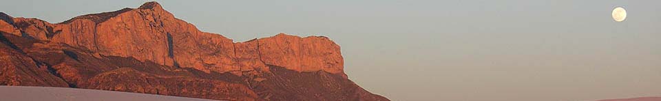 The Western Escarpment of the Guadalupes rises above the white gypsum sands of the desert floor.