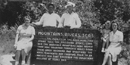 A group of park visitors pose around a wooden sign, circa 1940. A group of park visitors pose around a wooden sign, circa 1940.