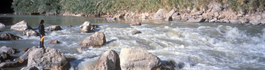 A lone kayaker regards the Rio Grande at the Hot Springs rapids