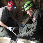 Rangers work to restore Middle Cave Lake, taking out many 5-gallon buckets of debris to reach the natural cave floor.