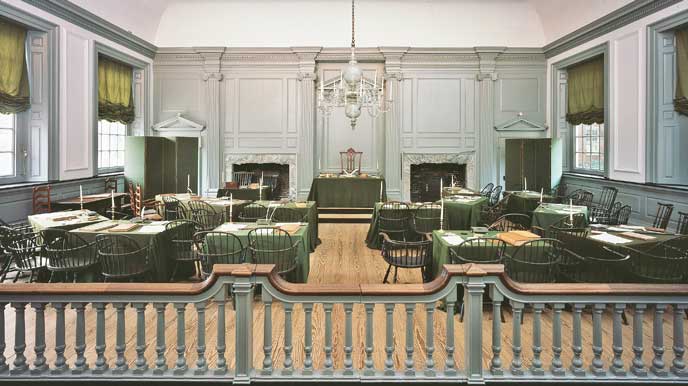 Assembly Room of Independence Hall with Windsor chairs around tables covered with green baize cloth.