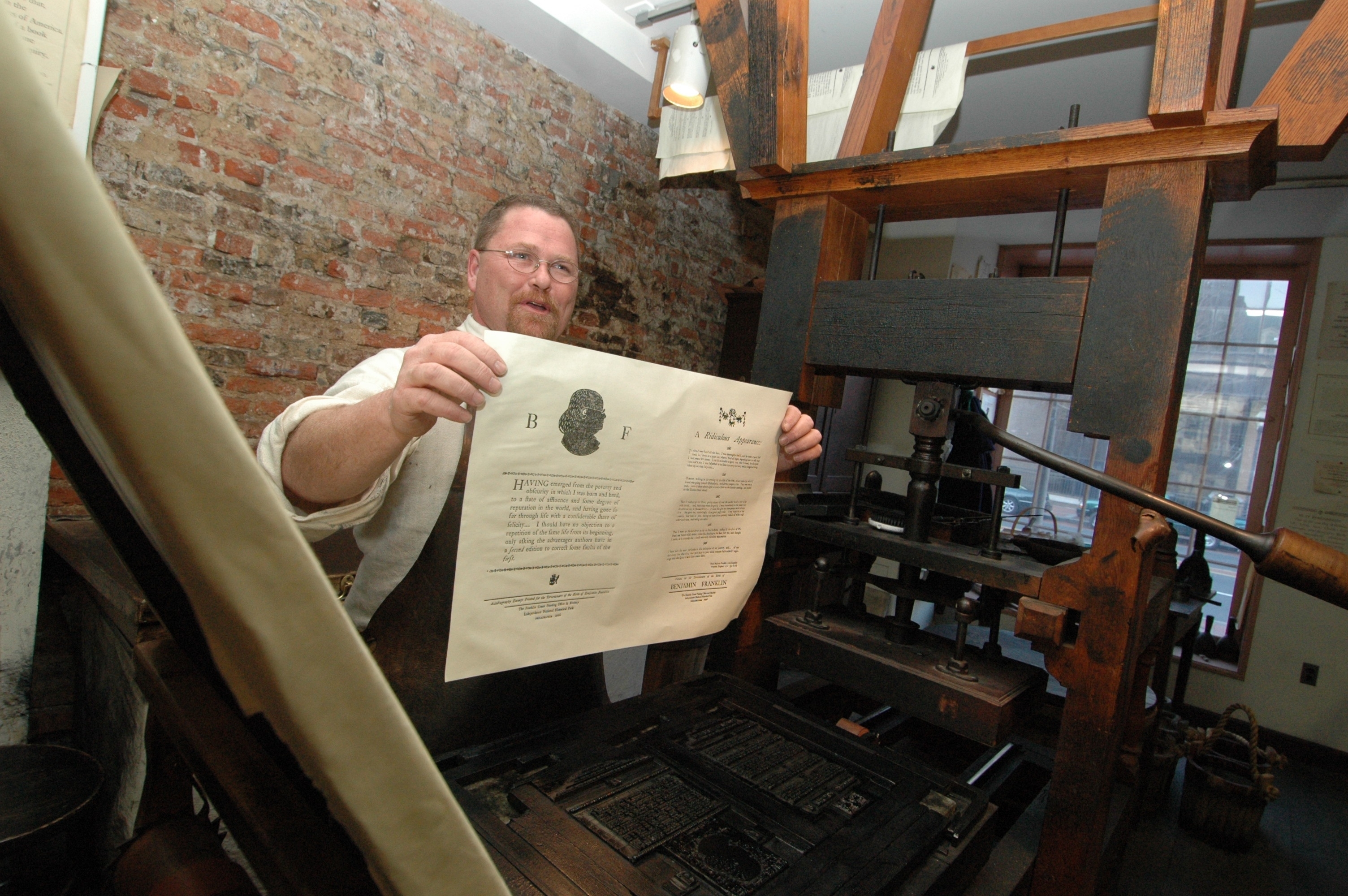 Ranger showing paper recently printed at Franklin Court Printing Office