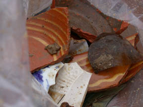 Photo of 18th century artifacts including sherds of plain and slip trailed red earthenware, Chinese porcelain, moulded white salt-glazed stoneware,