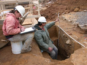 Photo of Archeologists recording the soil profile of an 18th century feature.
