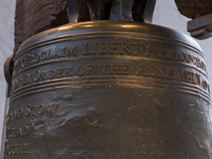 Color photo showing a detail of the Liberty Bell, focusing on the words "Proclaim LIBERTY" near the top of the bell.