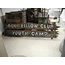 wooden sign made from 2 boards with the words Good Fellow Club Youth Camp painted in white, photo taken in a museum setting.