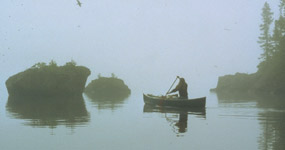 Canoeist paddling in the fog.