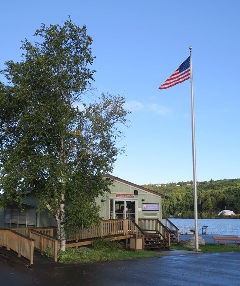Houghton Visitor Center front entrance with handicap accessible ramp and American flag flying.