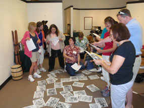 teachers at Civil War workshop look at reproductions of historic images displayed on floor of room