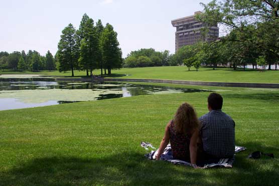 Couple with backs to camera sitting by the lagoon.