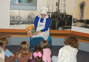 A storyteller dressed as a 1700s Cajun woman entertains children