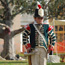 A young British bugler in an 1815 uniform stands at attention
