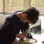 A boy looks through a microscope