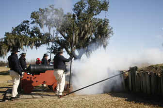 Image of men dressed as 1815 sailors firing a cannon