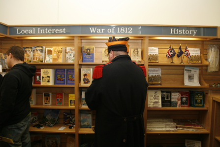 Image of man dressed in 1815 military uniform shopping at bookstore