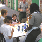 Kids and rangers work on a craft project during French Quarter Visitor Center summer camp