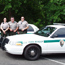 Three park rangers stand by their vehicle
