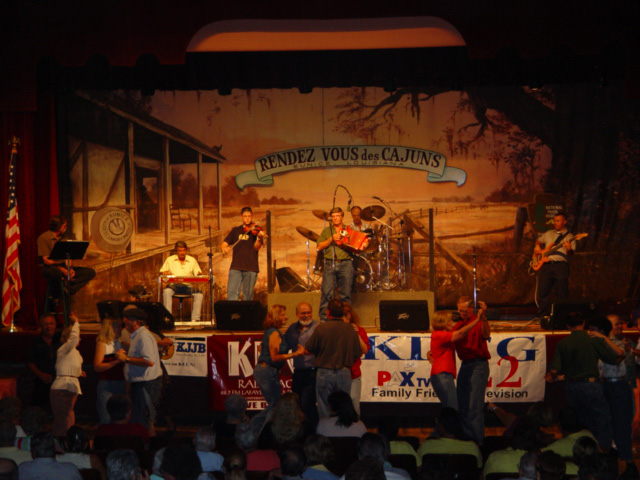 Image of people dancing in front of a stage where a Cajun band is playing