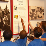 Boys in school uniforms look at an exhibit panel in the Acadian Cultural Center in Lafayette