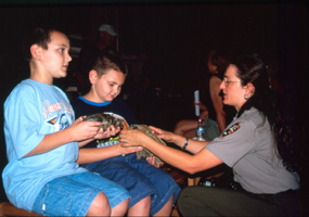 Image of a park ranger showing fossils to some children.