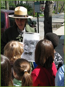 A ranger shows students a photo from JFK's boyhood in Brookline