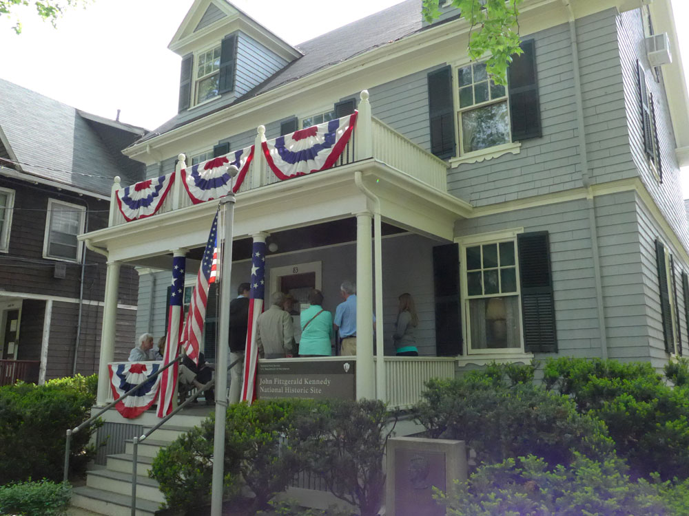 Visitors listen to a ranger on the front porch of John F. Kennedy's birthplace on his birthday.