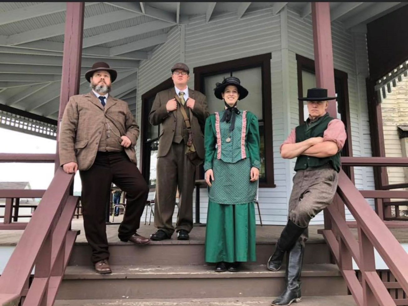A group of park rangers in costume on the clubhouse porch.
