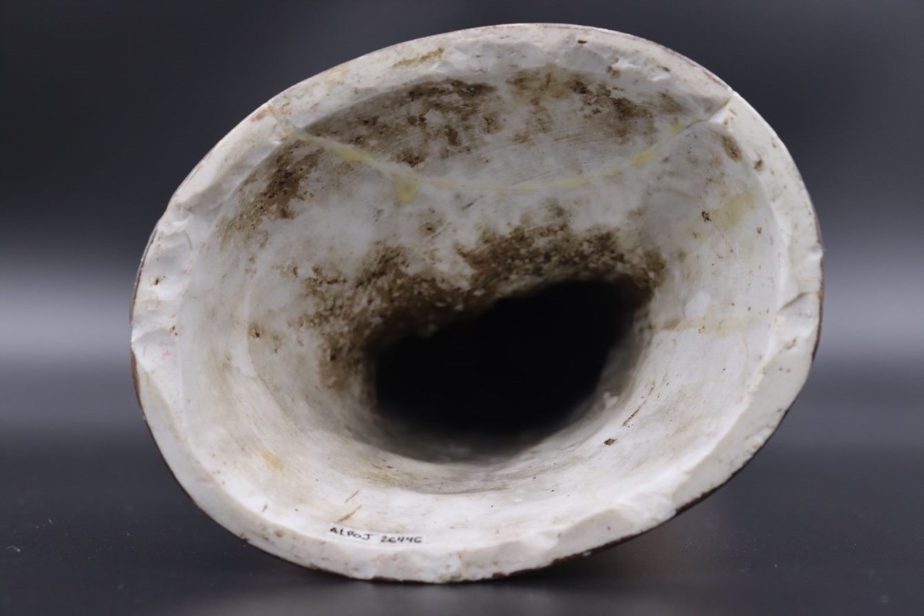 The hollow base of the figurine that once contained dirt from the flood