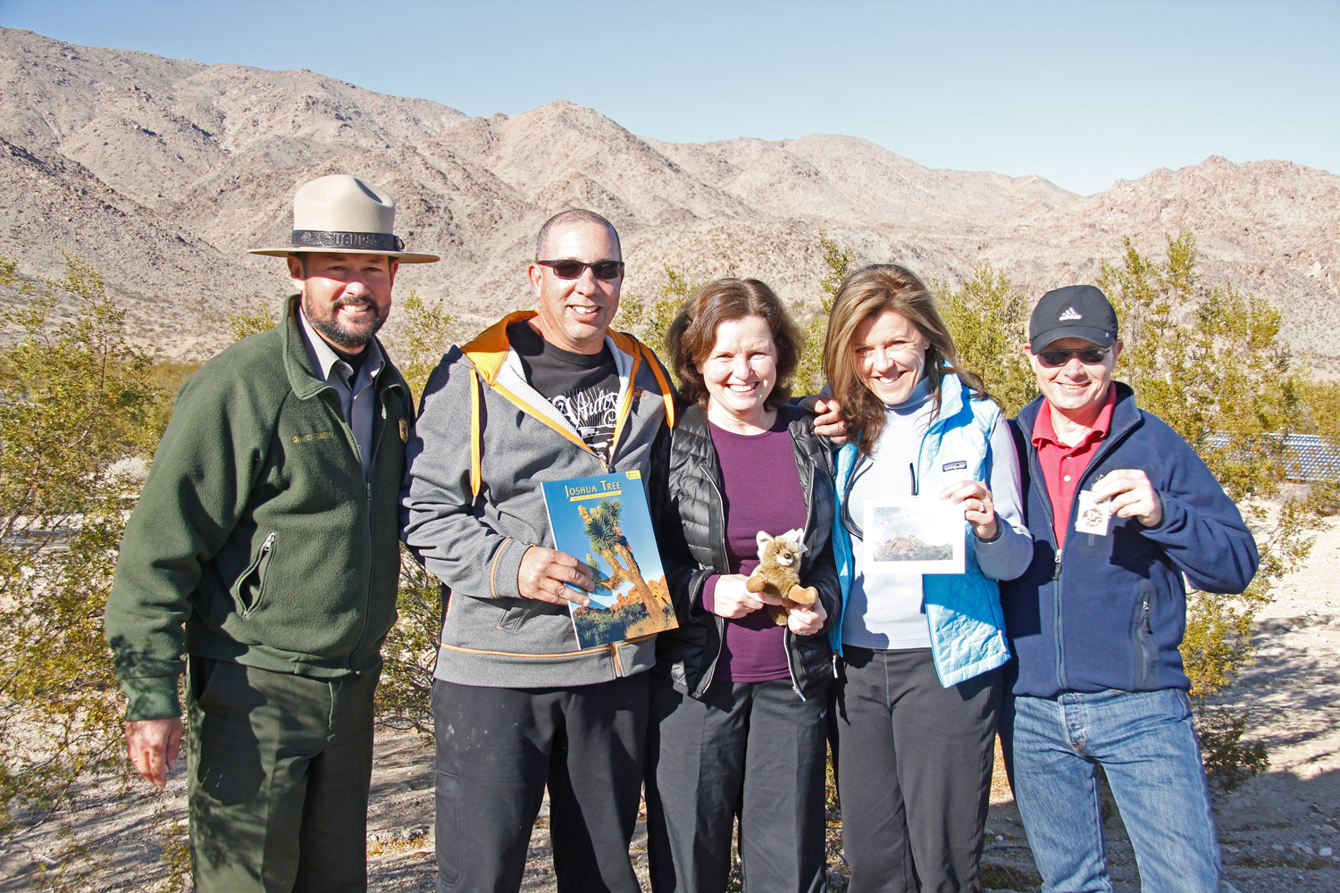 Four visitors stand with park Superintendent.