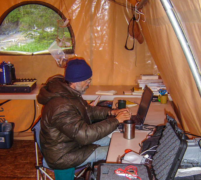 Dr. Crowell examining data in an archaeological field camp along the coast of Kenai Fjords National Park. Photo // NPS