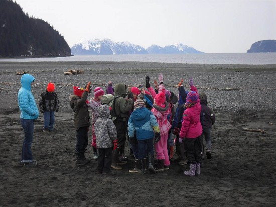 Ranger and students play an ecosystem game on the beach.