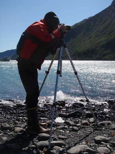 Park employee photographing glacial changes along park's coast.