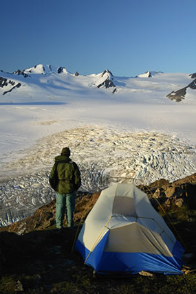Backpacker takes in the view at the edge of the Harding Icefield trail
