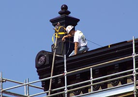 A new cornice and finials were installed to restore the original roof line.