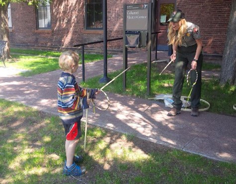 A child playing a historic game with a park ranger