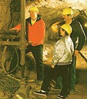 A tour guide demonstrates the use of a drill on a tour of the Delaware Mine.