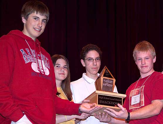 Winning team members Sara Anderson, Kyle Hawley, Derek O’Connell, and Ryan Young hold the Smackdown trophy.