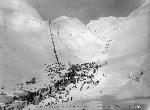 line of people on steep, snowy slope
