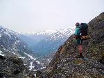 hiker stands on rock looking into mountains