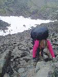 hiker on steep boulder slope using hands and feet
