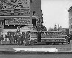 Black and white photo of old time street car