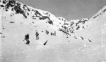 Black and white photo of men hiking mountain pass