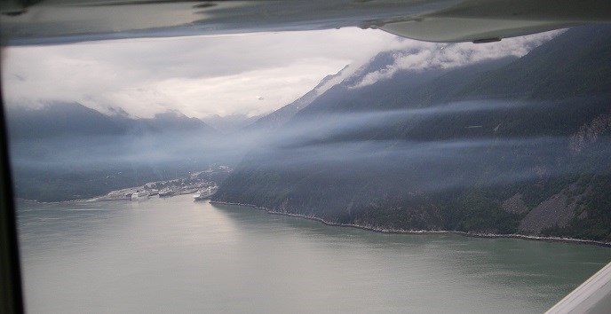 Layer of blue smog over water and town viewed from an airplane